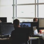 Pessoas trabalhando em computadores em um escritório.